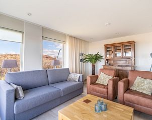 Ruime zithoek in Appartement Juliana 066 Zeezicht, De Koog, Texel met natuurlijke lichtinval en uitzicht op de omgeving.