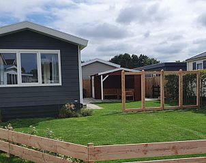 Chalet Bregkoog 154 in De Koog op Texel met groene tuin en houten hekwerk.