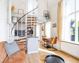 Gemtliches Wohnzimmer im Ferienhaus Plevierstraat 3a, De Koog, Texel, mit bequemem Sofa und viel Tageslicht.