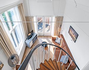 Private Terrasse am Ferienhaus Plevierstraat 3a, De Koog, Texel, mit Sitzgelegenheit und Holzzaun.