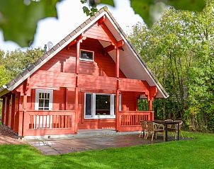 Charmantes Ferienhaus im Vakantiepark Het Oude Dijkje in De Koog, Texel, mit einer groen Veranda und grner Umgebung.