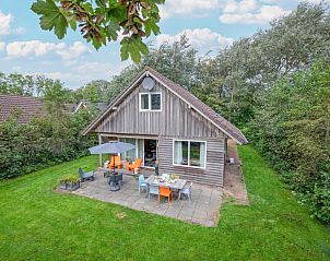 Vakantiepark Het Oude Dijkje - Hulfte, vakantiehuis met terras in De Koog, Texel omgeven door groen.