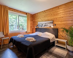 Sfeervolle slaapkamer in Vakantiepark Het Oude Dijkje - Hulfte, vakantiehuis De Koog, Texel met houten afwerking.