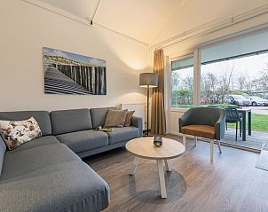 Gemtliches Wohnzimmer des T4M Comfort Bungalows in De Koog, Texel, mit moderner Einrichtung und Blick auf die grne Umgebung der Watteninseln.