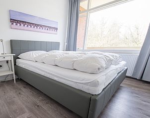 Comfortabele slaapkamer in 't Kerckeland - Appartement Kerckeland 88, De Koog, Texel, met groot raam en uitzicht op de natuur.