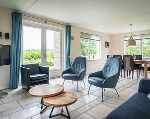 Gerumiges Wohnzimmer in der Villa fr 6 Personen, De Koog Texel, mit bequemen Sitzgelegenheiten und Gartenblick.
