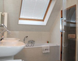Luxurises Badezimmer in der Villa 6 Personen, De Koog Texel, mit Badewanne, Dusche und viel Tageslicht.