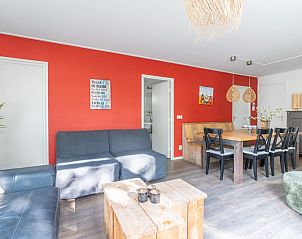 Ess- und Sitzecke im Bungalow De Nagtegaal 21, Bungalowpark De Nagtegaal, De Koog, Texel mit warmen roten Akzenten.