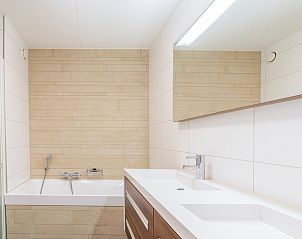 Luxe badkamer in Appartement Juliana 094 Eiland en Zeezicht, De Koog, Texel met bad en dubbele wastafel.