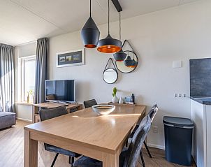 Eethoek in Appartement Juliana 118 Zeezicht, De Koog, Texel met designverlichting en houten tafel.