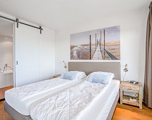 Ruime slaapkamer in Appartement Juliana 122 Eilandzicht, De Koog, Texel met toegang tot balkon en prachtig uitzicht.