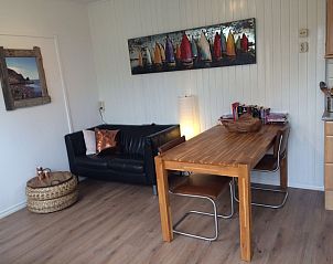 Gezellige woonkamer van Zomerhuisje Plevierstraat 12 in De Koog, Texel, met comfortabele zithoek en eettafel voor een ontspannen verblijf.