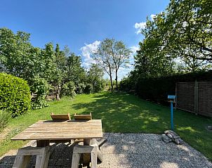 Ruim terras van Bungalow 't Luwe Land 5B in De Koog Texel met uitzicht op de tuin op de Waddeneilanden.