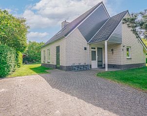 Achteraanzicht van Vakantiehuis Kamperfoelie 83 met sauna in De Koog Texel, omgeven door groen.