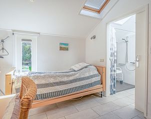 Ruime slaapkamer met uitzicht in Vakantiehuis Kamperfoelie 83 met sauna, De Koog Texel.