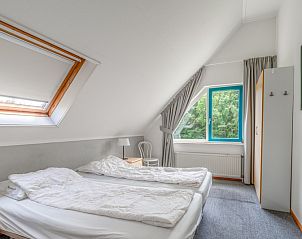 Lichte slaapkamer in Vakantiehuis Kamperfoelie 85, De Koog, Texel met comfortabele bedden en dakraam.