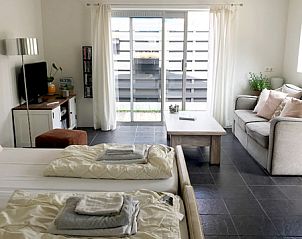 Lichte binnenruimte van Zomerhuisje Schoo in De Koog, Texel, met comfortabele zithoek.