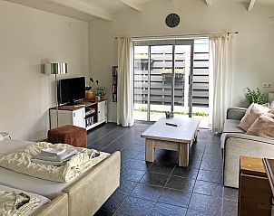 Gezellige woonkamer van Zomerhuisje Schoo in De Koog, Texel, met uitzicht op de tuin.