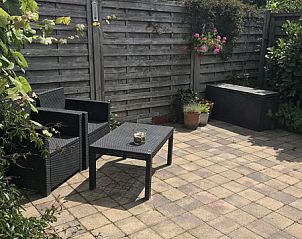 Privterras van Zomerhuisje Schoo in De Koog, Texel, omgeven door groene natuur.