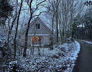 Stijlvolle woonkamer van vakantiehuis Hoog Koog 18 in De Koog, Texel, met uitzicht op de tuin in Bungalowpark Hoog Koog.