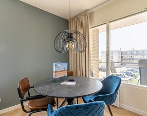 Moderne eetkamer in Appartement Juliana 120 Eilandzicht, De Koog, Texel met stijlvolle verlichting en uitzicht op de omgeving.