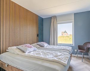 Comfortabele slaapkamer in Appartement Juliana 120 Eilandzicht, De Koog, Texel met tweepersoonsbed en uitzicht op de natuur.