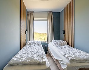 Knusse slaapkamer in Appartement Juliana 120 Eilandzicht, De Koog, Texel met twee eenpersoonsbedden en uitzicht op het landschap.
