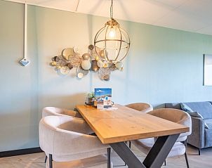 Eethoek in Appartement Juliana 044 Eiland en Zeezicht, De Koog, Texel met houten tafel en sfeervolle verlichting.