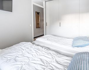 Ruime slaapkamer in Appartement Juliana 044 Eiland en Zeezicht, De Koog, Texel met inbouwkasten en zachte bedden.