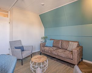 Moderner Innenraum des Appartements Zeedistel 28, De Koog, Texel, mit bequemem Sofa und Sesseln.