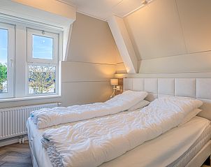 Helles Schlafzimmer im Apartment Zeedistel 28, De Koog, Texel, mit bequemem Bett und Blick auf die Natur.