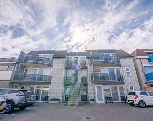 Vorderseite des Appartements Zeedistel 28, De Koog, Texel, mit Parkplatz und moderner Architektur.