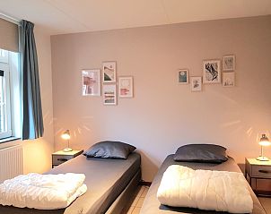 Sfeervolle slaapkamer in T6BM bungalow, De Koog, Texel, met comfortabele bedden en serene inrichting.