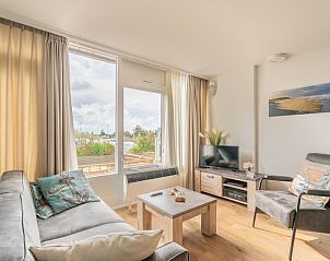 Lichte leefruimte van Appartement Juliana 076 Eilandzicht in De Koog, Texel met comfortabele zithoek en buitenzicht.