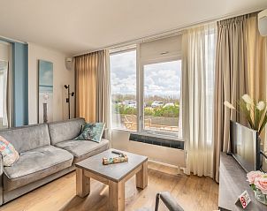 Stijlvolle binnenruimte van Appartement Juliana 076 Eilandzicht, De Koog, Texel met uitzicht op groene omgeving.