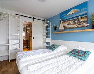 Stijlvolle slaapkamer in Appartement Juliana 076 Eilandzicht, De Koog, Texel met strandthema en comfortabele bedden.