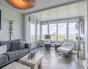 Gezellige woonkamer van Appartement Juliana 106 Zeezicht in De Koog, Texel met grote ramen en uitzicht op de natuur.