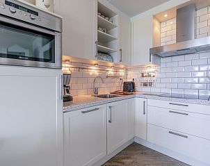 Moderne keuken van Appartement Juliana 106 Zeezicht in De Koog, Texel met witte kasten en luxe apparatuur.