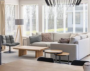 Stijlvolle woonkamer in Villa 8, een vakantiehuis in De Koog, Texel. Gezellige zithoek met houtkachel en uitzicht op de natuur.