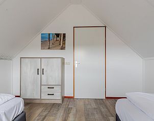 Slaapkamer in T6B Comfort bungalow in De Koog, Texel met houten vloer en lichte inrichting, ideaal voor een ontspannen verblijf op de Waddeneilanden.