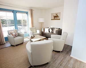 Gezellige woonkamer in T6AM Comfort bungalow, De Koog, Texel, met comfortabele zitruimte en uitzicht op de tuin.