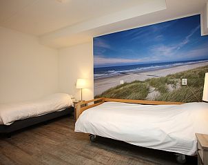 Slaapkamer in T6AM Comfort bungalow in De Koog, Texel, met stranddecor voor een rustgevende vakantie-ervaring op de Waddeneilanden.