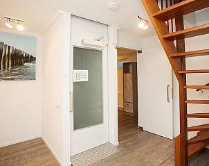 Binnenruimte van T6AM Comfort bungalow in De Koog, Texel met moderne trap en kunst aan de muur, ideale vakantiewoning op de Waddeneilanden.