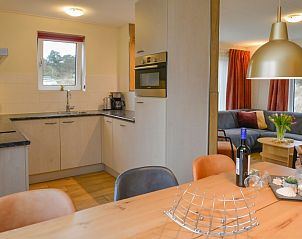 Gezellige keuken in De Eik, Texel met uitzicht op de tuin en eetruimte.