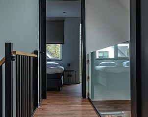 Gang met houten vloer in vakantiehuis 36 - 12 Bonte Specht in De Koog, Texel, leidt naar slaapkamers.