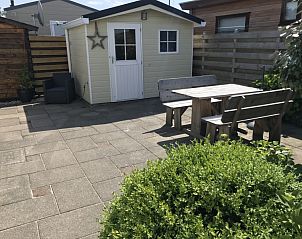 Terras met houten meubelen bij Chalet Bregkoog 255, De Koog, Texel, ideaal voor buiteneten.