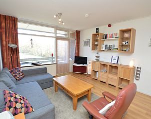 Gezellige woonkamer in Appartement Kerckeland 50, De Koog, Texel met comfortabele zithoek en uitzicht op de natuur.