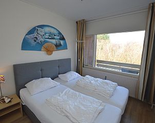 Comfortabele slaapkamer in Appartement Kerckeland 50, De Koog, Texel met tweepersoonsbed en uitzicht op de natuur.
