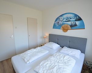 Stijlvolle slaapkamer in Appartement Kerckeland 50, De Koog, Texel met artistieke decoratie en zachte verlichting.