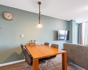 Eethoek in Appartement Juliana 124 Eilandzicht, De Koog, Texel met houten tafel en moderne stoelen.